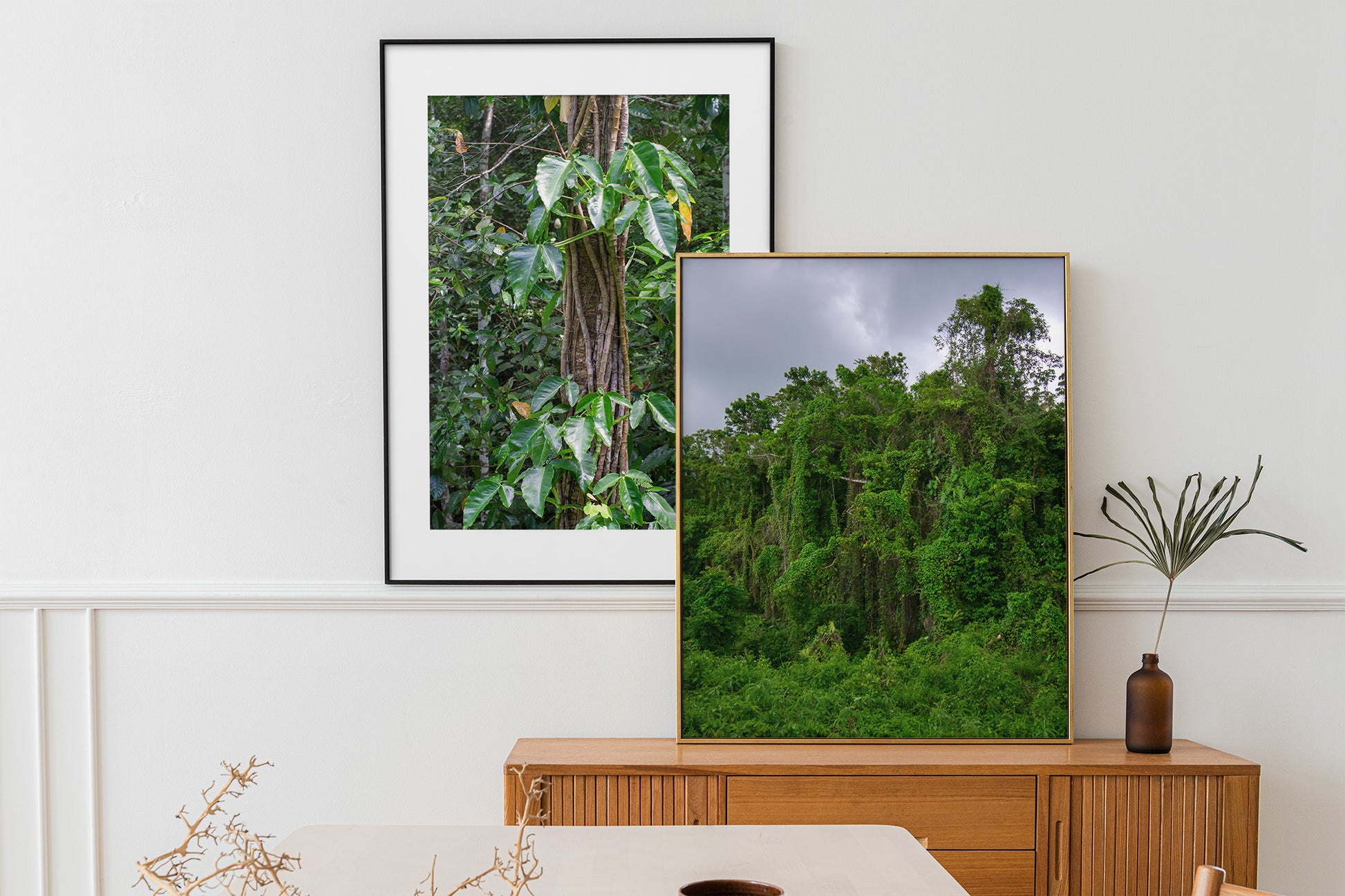 A photo of wild trees and vines under a cloudy sky in the hills of Hanover, Jamaica in a gallery wall above a buffet.